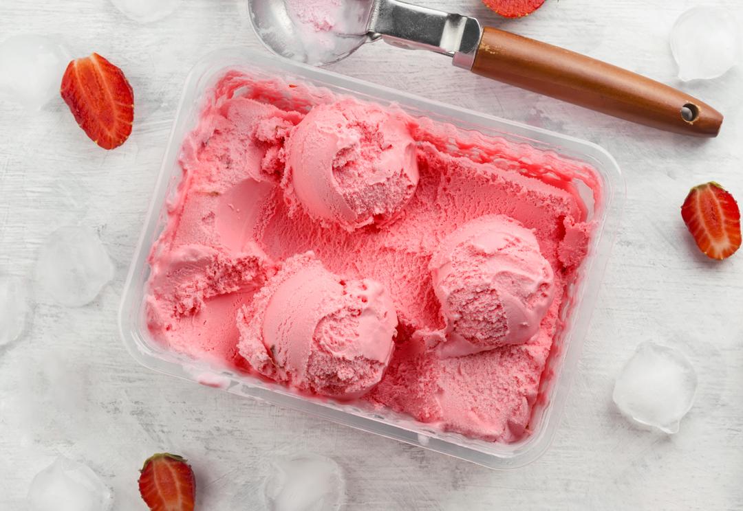 Pink strawberry and coconut ice cream scoops on plate stock photo